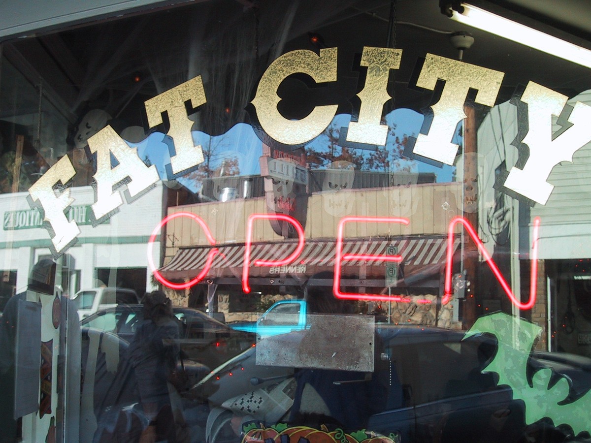 Signage at the Fat City diner window, and a lit neon sign reading OPEN