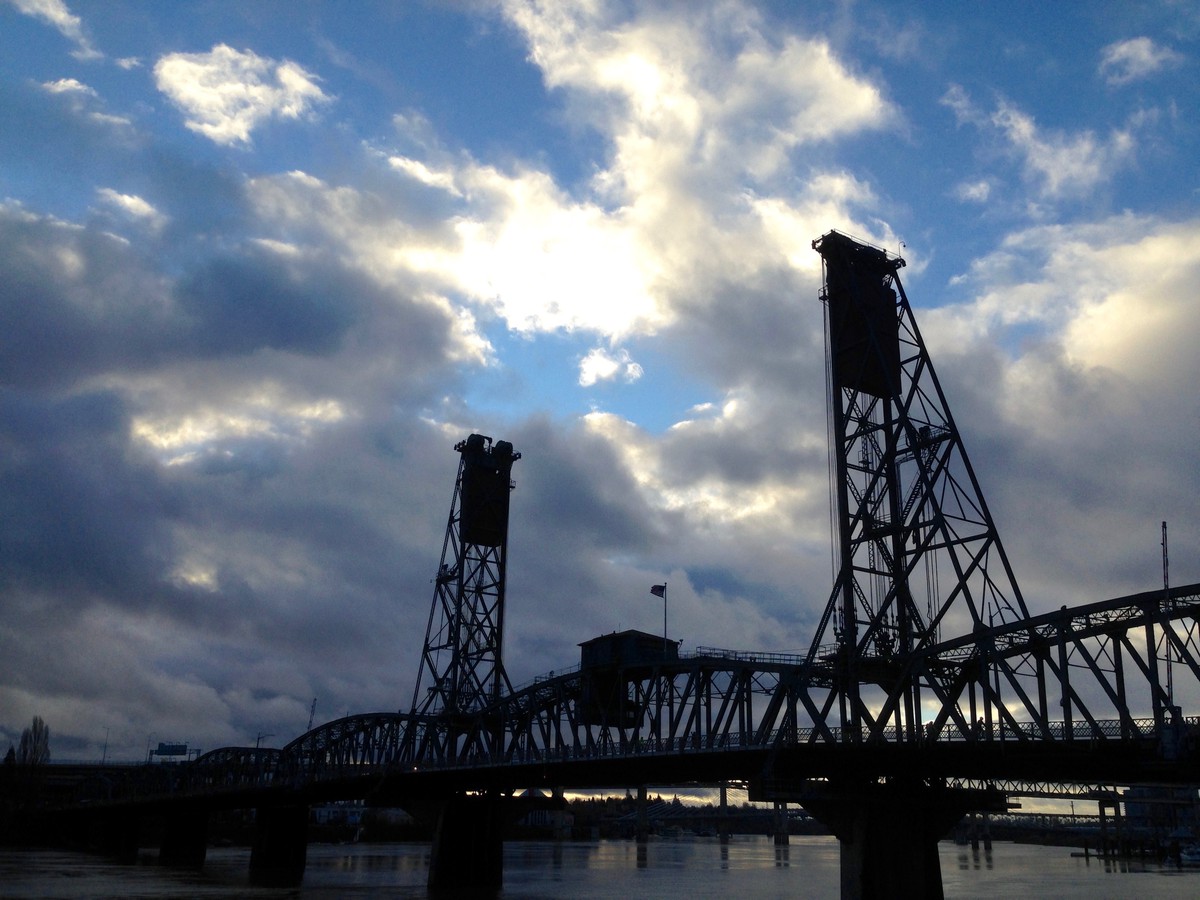 Hawthorne bridge in silhouette against a dark, windy, cloudy, morning sky
