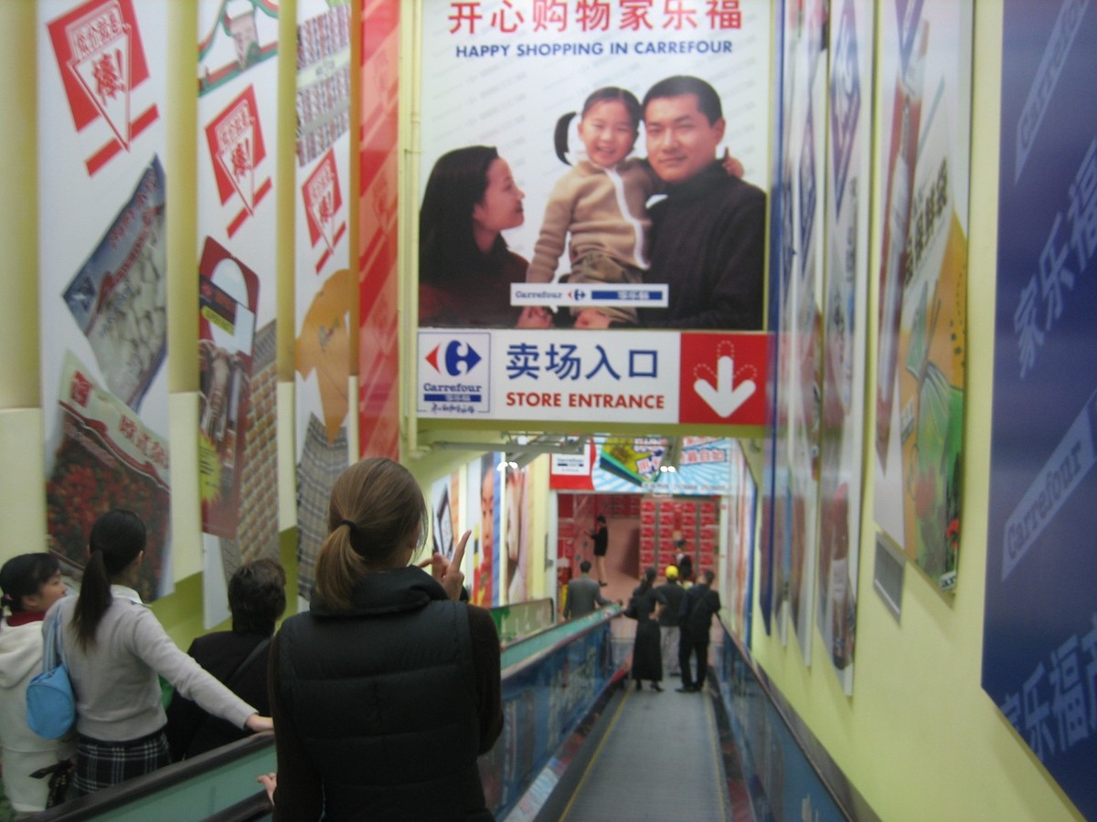 Jenny descending an escalator into Carrefour department store in Xiamen