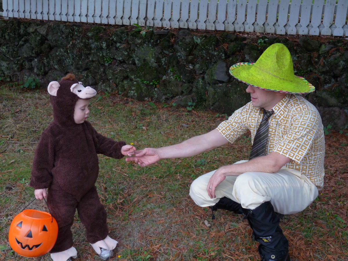 A toddler in a monkey costume and a man in a yellow hat, for Halloween