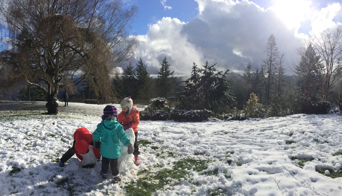 Kids building a snow person at Pittock Mansion