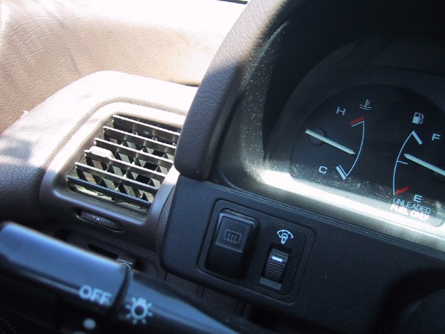 Closeup of part of a car’s control panel, the engine temperate gauge is the only notable item, it is almost exactly halfway between Cold and Hot