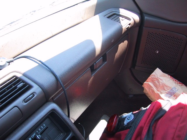 Backpack and fast food bag on the floor of a car