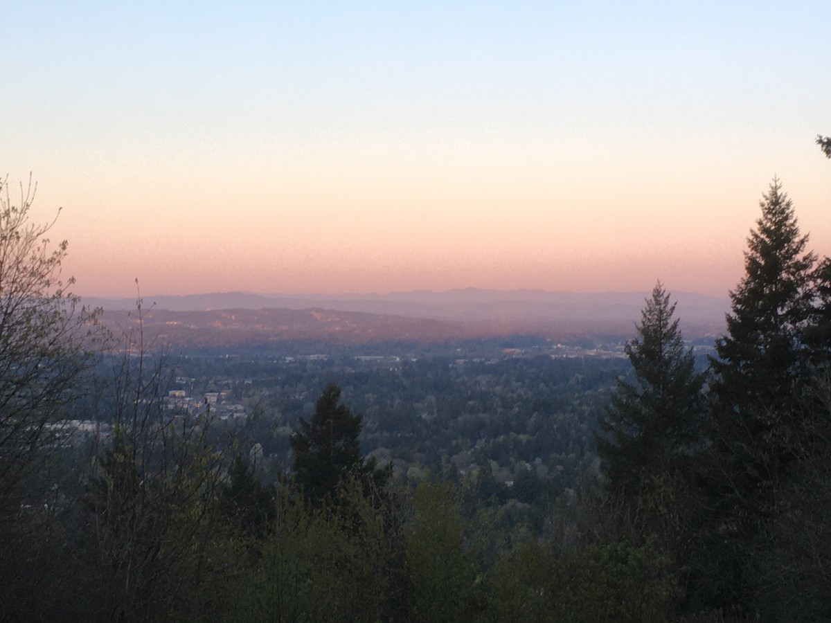 Sunrise on an exceptionally clear morning looking southwest from Council Crest into the Tualatin Valley. The shadow of Council Crest, including the distinctive knob where the park is located, is visible against the landscape below