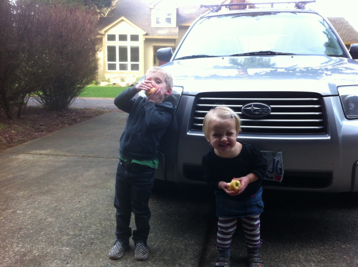 Kiddos in front of the Forester, eating apples