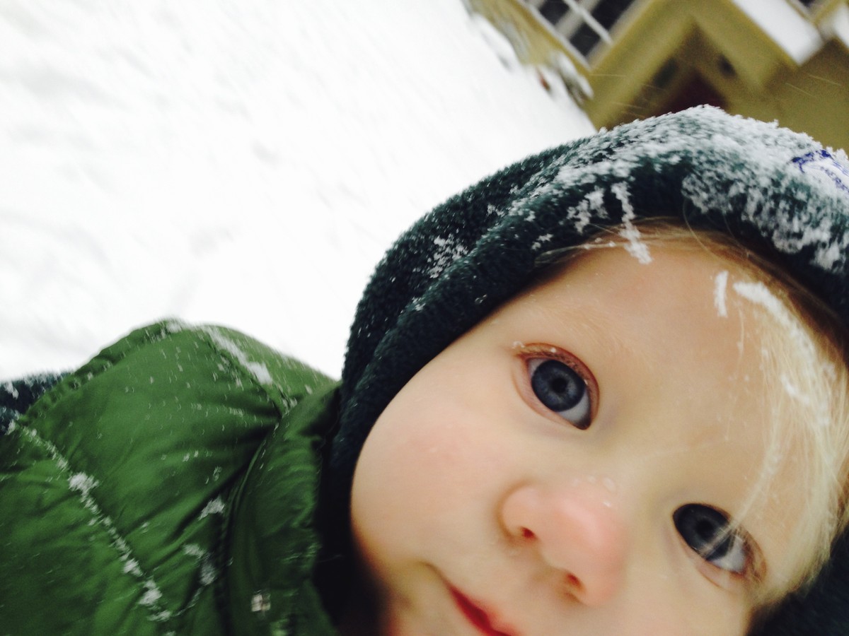Closeup of a child in snow clothes, outdoors in the snow