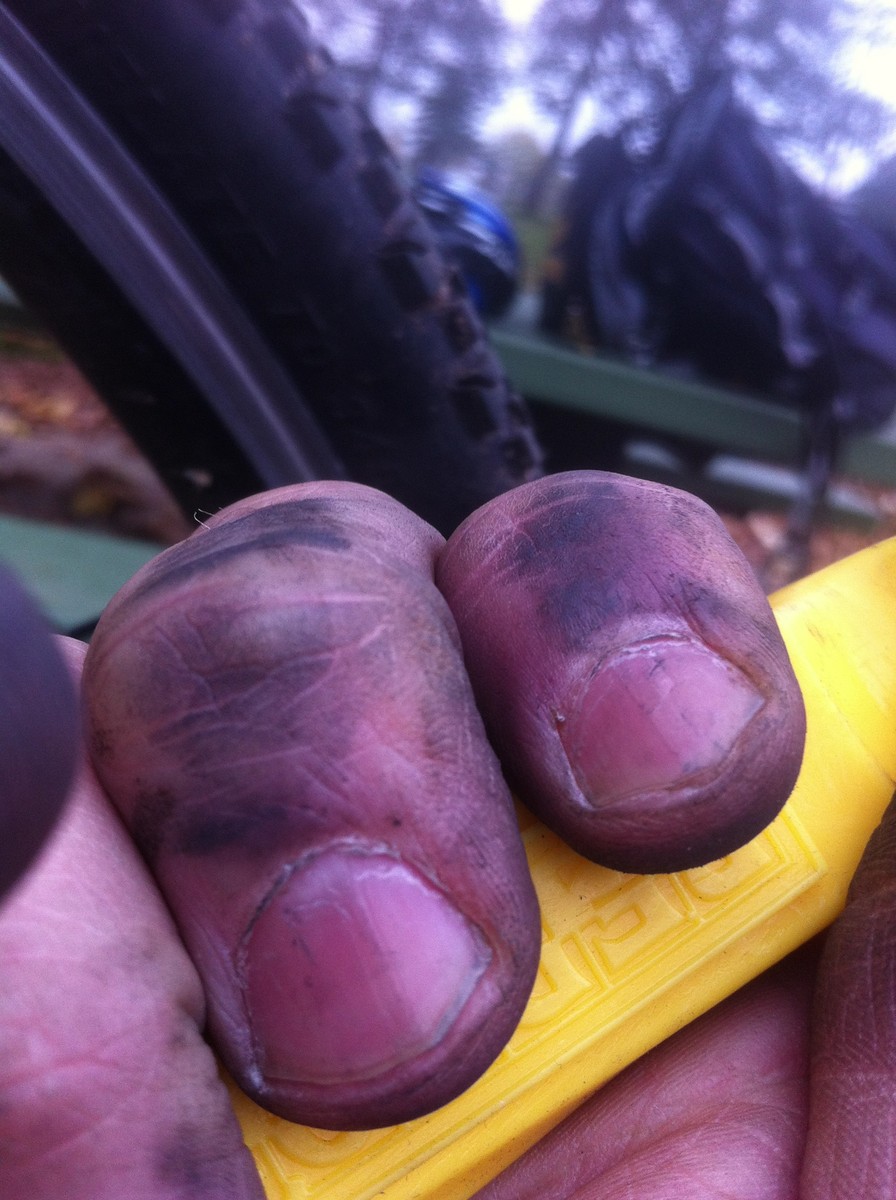 Dirty fingers holding a tire lever
