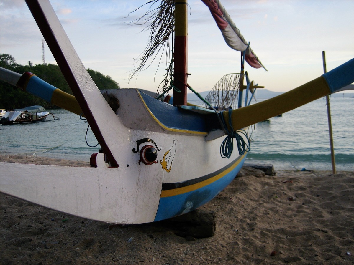A boat with a painted face, on a beach in Bali