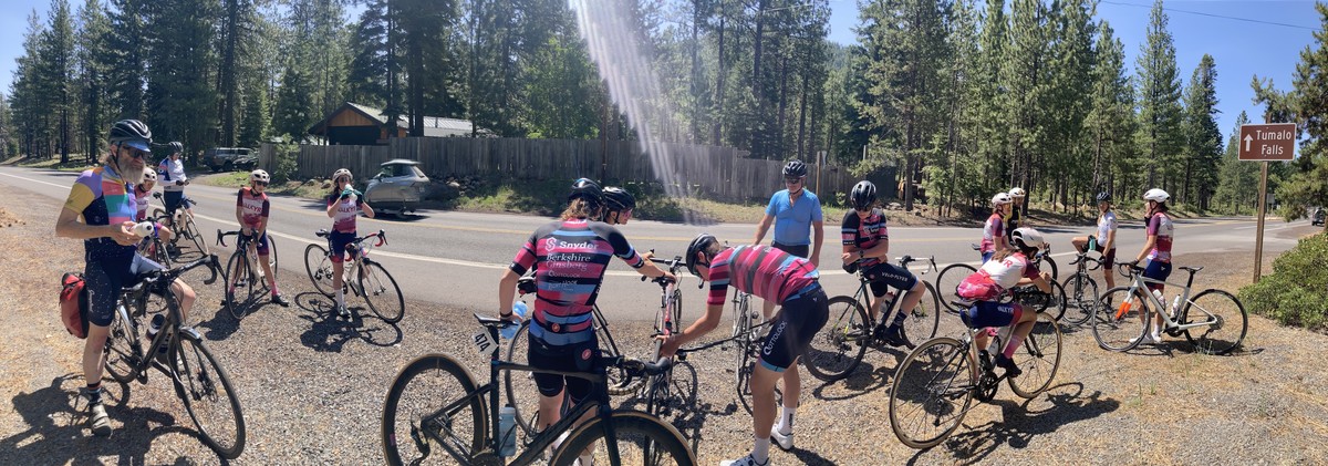 Pano of riders with VALKYR and EPYC at the top of Skyliners, at the Tumalo Falls sign, taking a break, drinking water