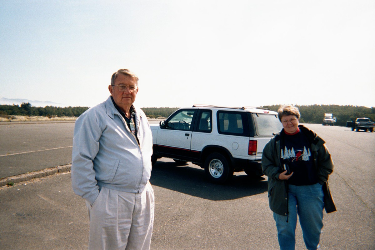 Two young retirees in windbreakers in a beach parking lot