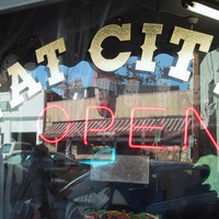 Signage at the Fat City diner window, and a lit neon sign reading OPEN