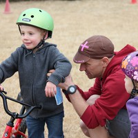 Paul pinning a race number on Orion while Iris watches, 2012