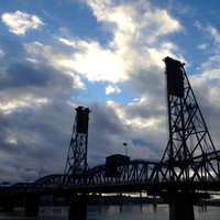 Hawthorne bridge in silhouette against a dark, windy, cloudy, morning sky