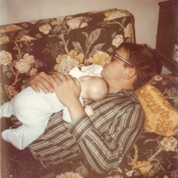 Scan of a photo from 1971. A man — my father — napping on a couch, with an infant — myself — asleep on his chest