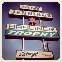 Photo of the old (1960s era) sign: “Staff Jennings / Bayliner Trophy / Jetcraft.” Photo manipulated to resemble a faded Polaroid from the 1970s