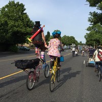 Olive Rootbeer and Dingo Dizmal on tall bikes, holding hands, shot from behind. Photo by @__P__J