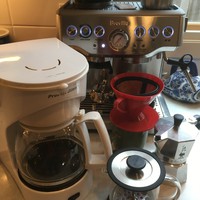 A collection of coffee makers on a kitchen counter: cheap electric auto drip coffee maker; small French Press; stovetop Bialetti espresso machina; simple pour-over cone; large and fancy Breville espresso machine & steamer with a built-in grinder