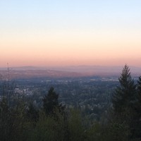 Sunrise on an exceptionally clear morning looking southwest from Council Crest into the Tualatin Valley. The shadow of Council Crest, including the distinctive knob where the park is located, is visible against the landscape below