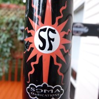 Closeup of head badge on a Soma Doublecross bicycle: Logo is a stylized “SF” in a sunburst, with “SOMA Fabrications” just below it