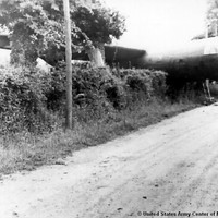Historic photo of a cargo glider crashed in a hedge in Normandy. © United States Army Center of Military History
